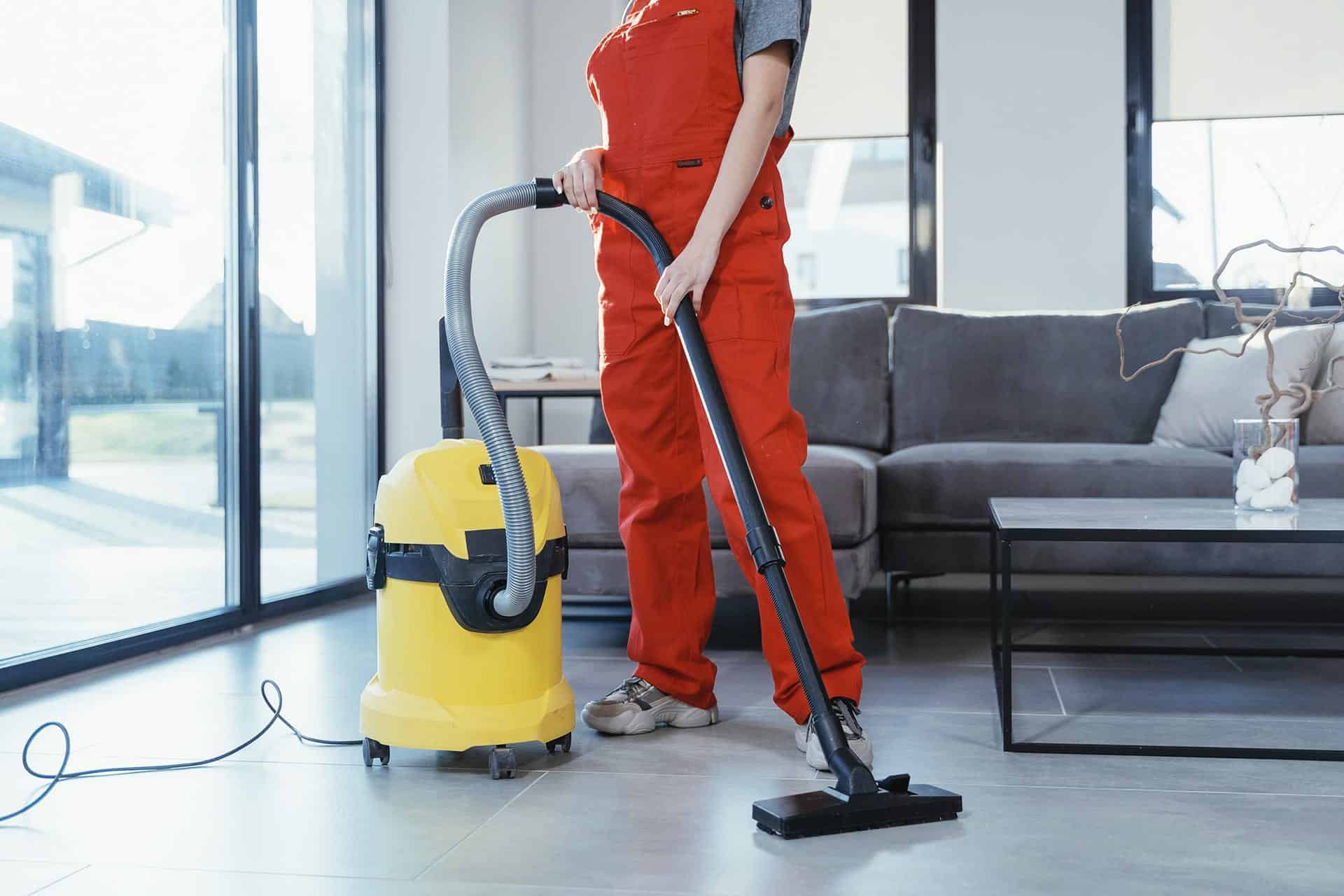 Person in red overalls vacuuming